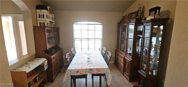 dining room featuring light tile patterned floors and vaulted ceiling