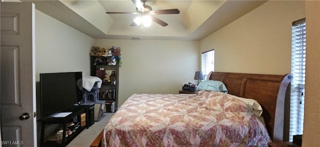 bedroom with ceiling fan and a tray ceiling