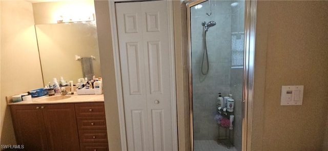 bathroom with a shower with shower door and vanity