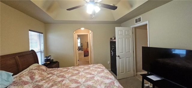 bedroom with ceiling fan and a tray ceiling