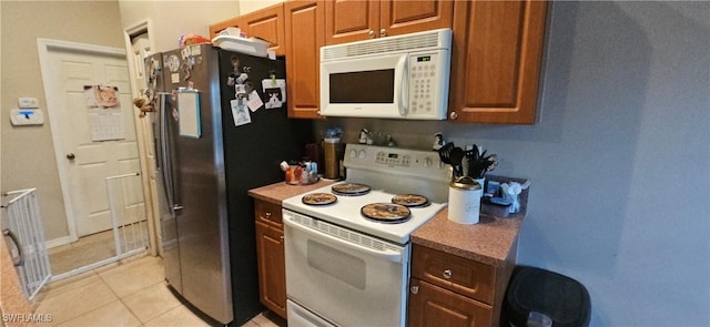 kitchen with white appliances and light tile patterned flooring