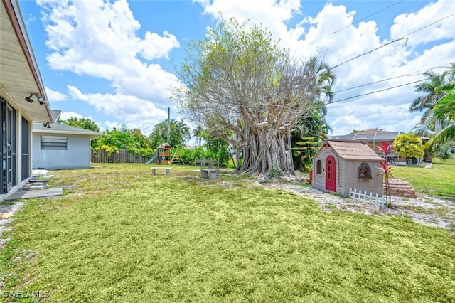 view of yard featuring a storage unit and a playground