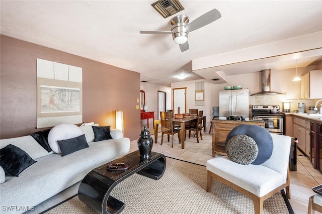 living room with sink, ceiling fan, and light tile patterned floors