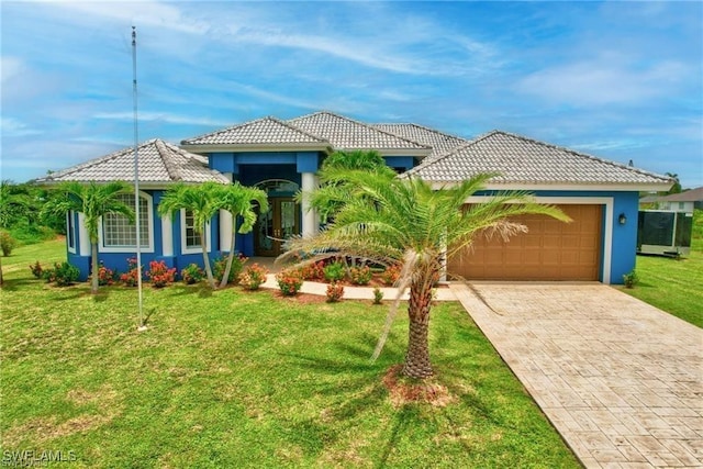 mediterranean / spanish home with a garage and a front lawn