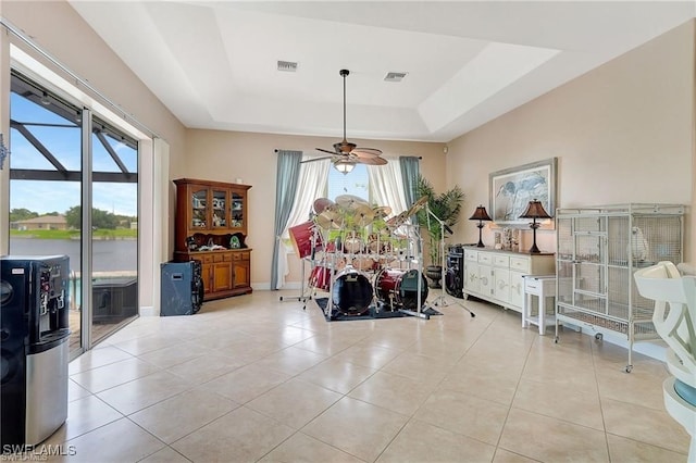 dining space featuring a raised ceiling, visible vents, and a healthy amount of sunlight