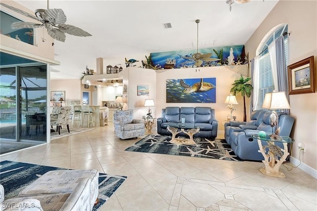 tiled living area with visible vents, ceiling fan, and baseboards