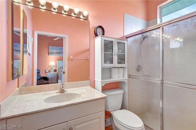 full bathroom featuring a stall shower, connected bathroom, vanity, and toilet