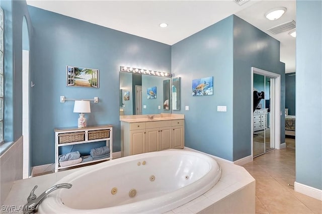 bathroom featuring baseboards, visible vents, tile patterned floors, a whirlpool tub, and vanity