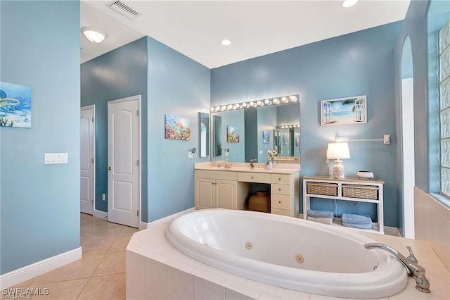 bathroom with tile patterned flooring, vanity, visible vents, baseboards, and a tub with jets