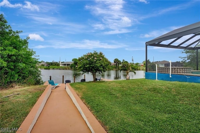 view of yard featuring glass enclosure and a water view