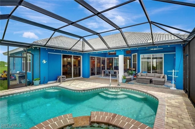 outdoor pool with a patio area, ceiling fan, glass enclosure, and an outdoor living space