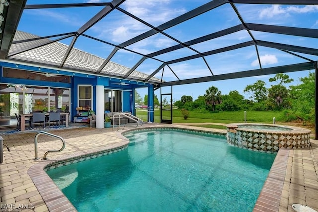 view of swimming pool with ceiling fan, a lanai, a yard, a patio area, and a pool with connected hot tub