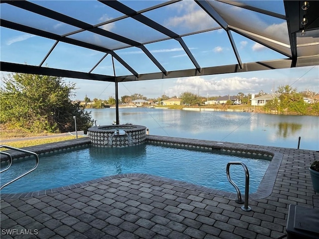 view of pool with a patio area, glass enclosure, a water view, and a pool with connected hot tub