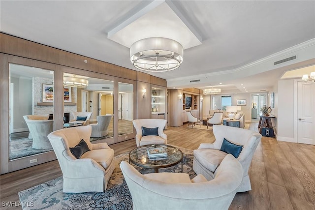 interior space with hardwood / wood-style floors, wood walls, a chandelier, and ornamental molding