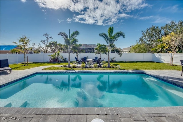 view of pool with a patio area and a yard