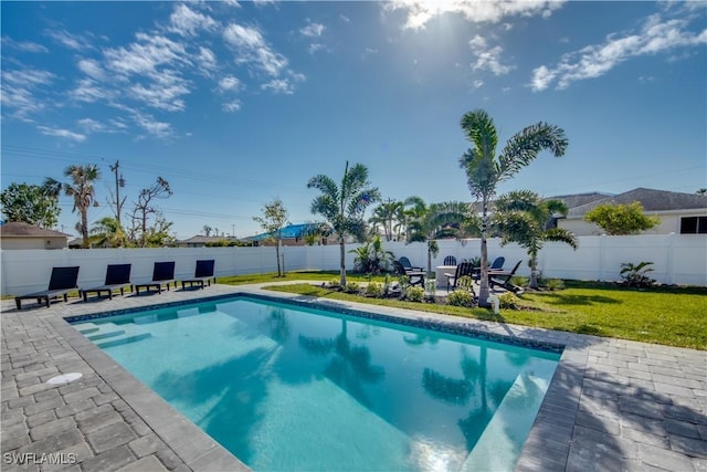 view of pool featuring a lawn and a patio