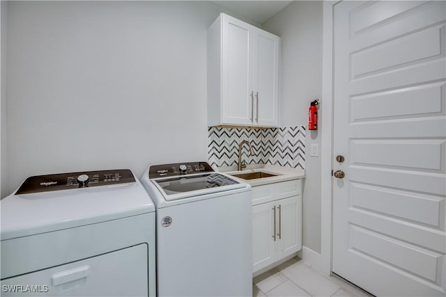 laundry room with cabinets, separate washer and dryer, light tile patterned floors, and sink