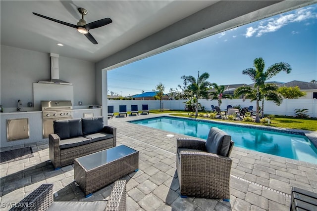 view of pool featuring a patio area, a grill, an outdoor kitchen, and ceiling fan