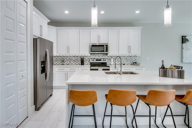 kitchen featuring appliances with stainless steel finishes, pendant lighting, and white cabinets