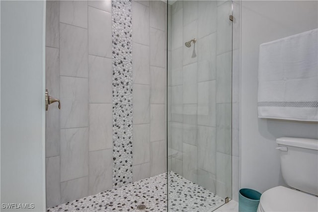 bathroom featuring toilet and tiled shower