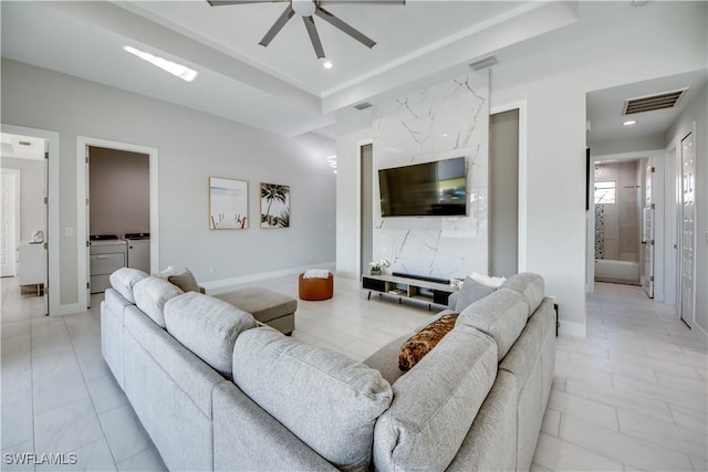 living room with ceiling fan and washer and dryer