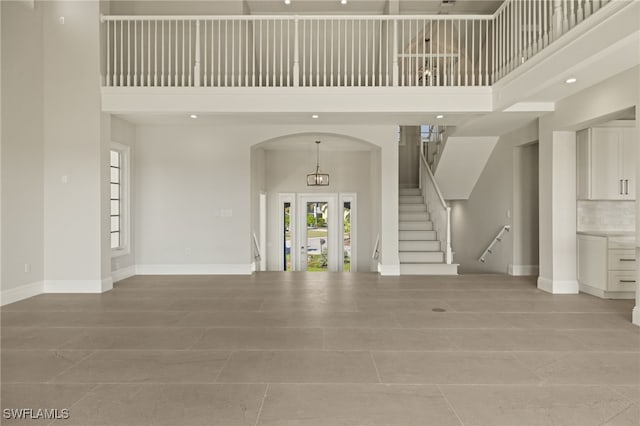 tiled entrance foyer with a towering ceiling