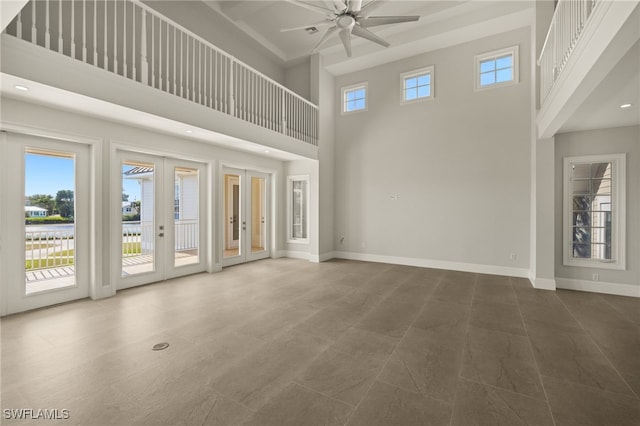 unfurnished living room with french doors, a high ceiling, and ceiling fan