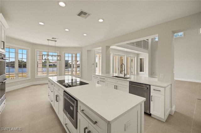 kitchen featuring kitchen peninsula, stainless steel dishwasher, pendant lighting, black electric stovetop, and sink