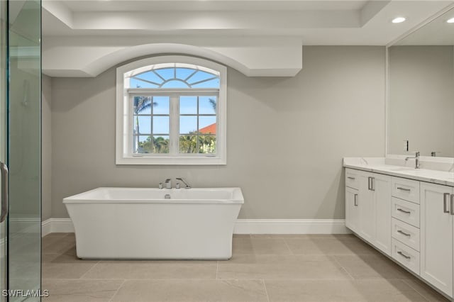 bathroom with a washtub, tile patterned floors, and vanity