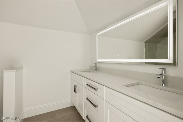 bathroom featuring tile patterned floors, lofted ceiling, and vanity