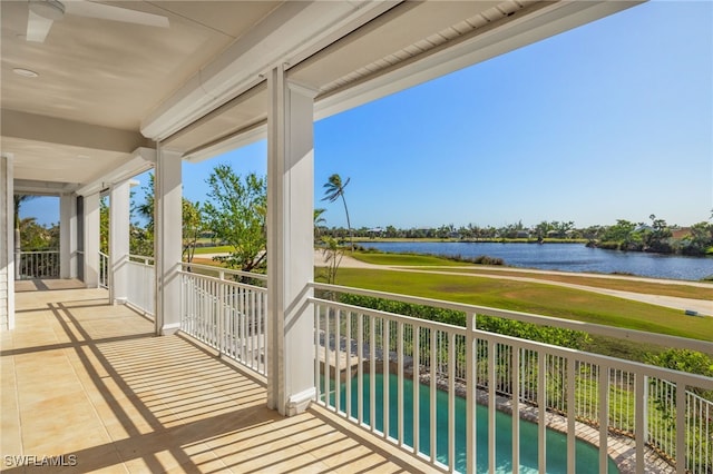 balcony with ceiling fan and a water view