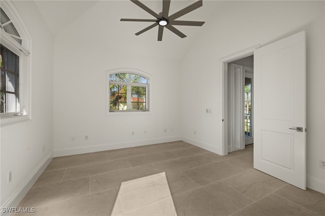 unfurnished room with high vaulted ceiling, ceiling fan, and plenty of natural light