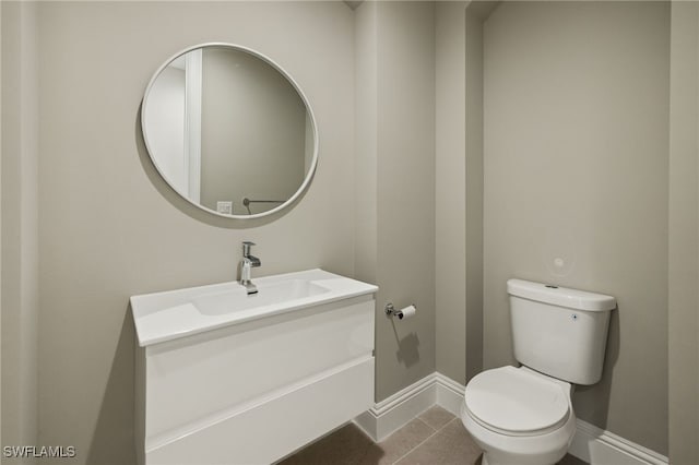 bathroom with toilet, tile patterned floors, and vanity