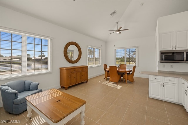 living room with ceiling fan, a wealth of natural light, and light tile patterned floors