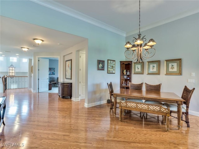 dining room featuring an inviting chandelier, light hardwood / wood-style floors, and crown molding