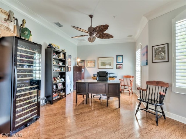 home office featuring beverage cooler, ceiling fan, crown molding, and a healthy amount of sunlight