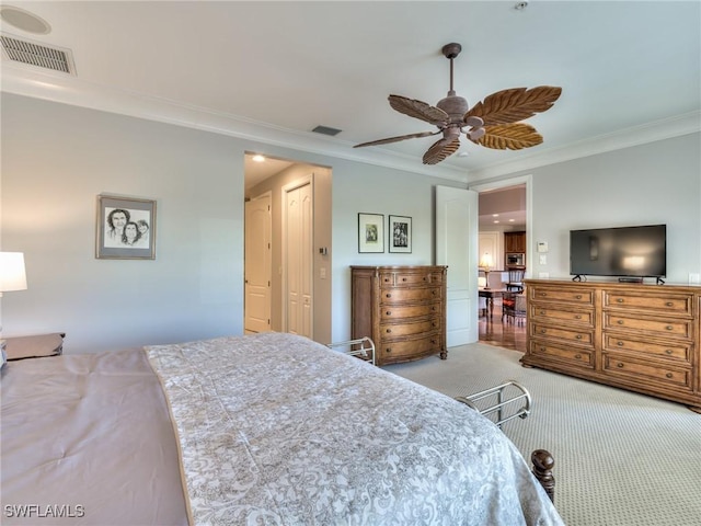 carpeted bedroom with ceiling fan and crown molding