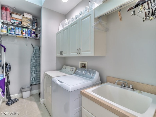 laundry area with sink, cabinets, washing machine and clothes dryer, and light tile patterned floors