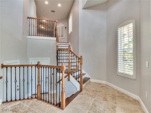 stairs featuring a towering ceiling