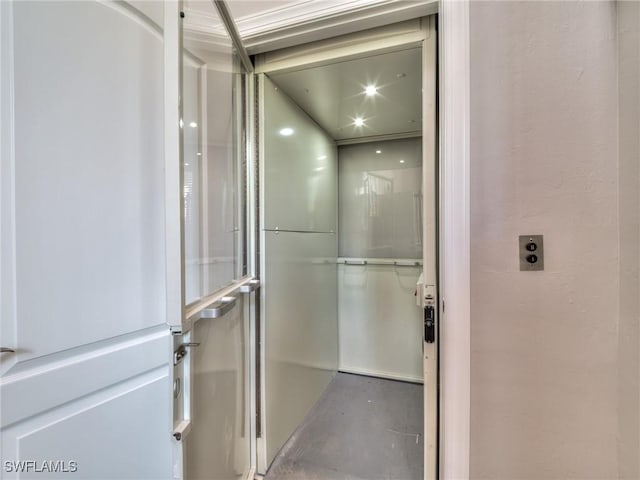 bathroom featuring elevator and concrete floors