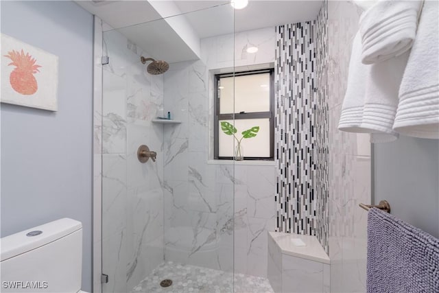 bathroom featuring toilet and tiled shower