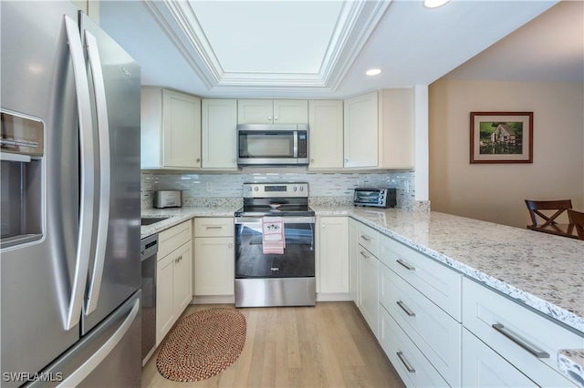 kitchen with light stone counters, backsplash, appliances with stainless steel finishes, and ornamental molding