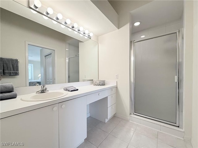 bathroom with tile patterned flooring, walk in shower, and vanity