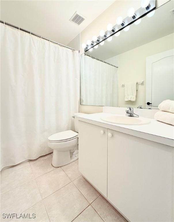 bathroom featuring toilet, vanity, and tile patterned floors