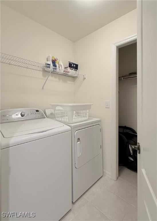 laundry room featuring washer and dryer and light tile patterned floors