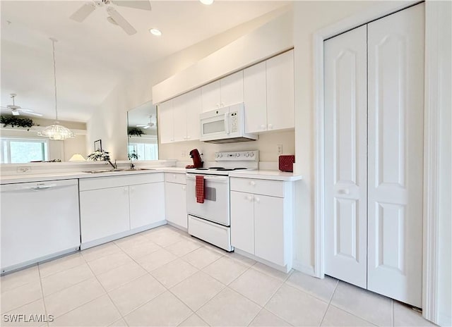 kitchen with decorative light fixtures, white cabinets, lofted ceiling, white appliances, and light tile patterned floors