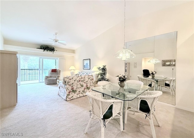 carpeted dining room with ceiling fan and lofted ceiling