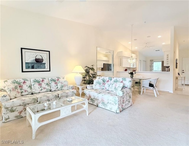 living room featuring ceiling fan, vaulted ceiling, and light carpet