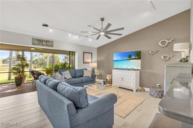 living room with lofted ceiling, light hardwood / wood-style floors, rail lighting, and ceiling fan