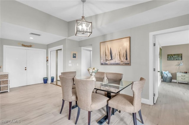 dining space with a notable chandelier and light wood-type flooring